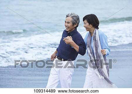Stock Photo - Senior Japanese couple at the beach. Fotosearch