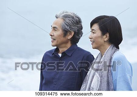 Stock Photography - Senior Japanese couple at the beach. Fotosearch