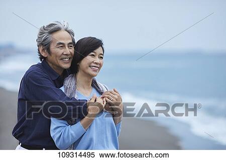 Stock Photography - Senior Japanese couple at the beach. Fotosearch