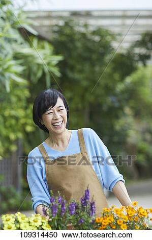 Stock Image - Senior Japanese woman gardening. Fotosearch