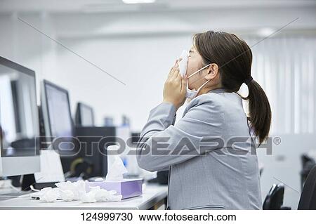 Stock Image - Sick Japanese businesswoman in the office. Fotosearch