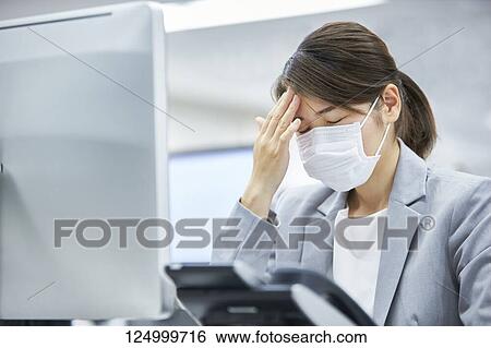 Stock Photograph - Sick Japanese businesswoman in the office. Fotosearch