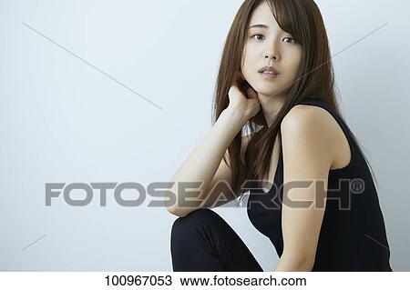 Stock Image - Studio portrait of attractive young Japanese woman. Fotosearch