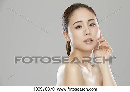 Stock Image - Studio portrait of attractive young Japanese woman. Fotosearch