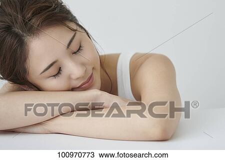 Stock Image - Studio portrait of attractive young Japanese woman. Fotosearch