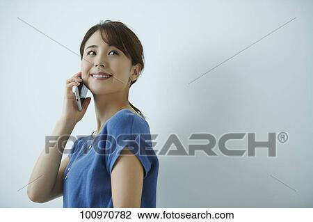 Stock Image - Studio portrait of attractive young Japanese woman. Fotosearch