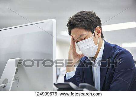 Stock Photograph - Tired Japanese businessman in the office. Fotosearch