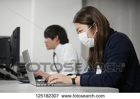 Stock Photo - Tired Japanese businesswoman in the office. Fotosearch