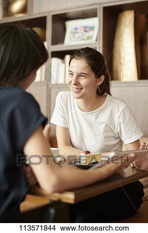 Young girlfriends at a cafe View Large Photo Image Picture - Young girlfriends at a cafe. Fotosearch