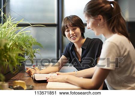 Young girlfriends at a cafe View Large Photo Image Stock Image - Young girlfriends at a cafe. Fotosearch