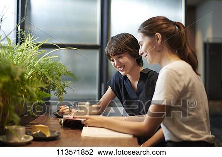 Young girlfriends at a cafe View Large Photo Image Stock Image - Young girlfriends at a cafe. Fotosearch