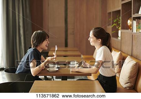 Young girlfriends at a cafe View Large Photo Image Stock Image - Young girlfriends at a cafe. Fotosearch