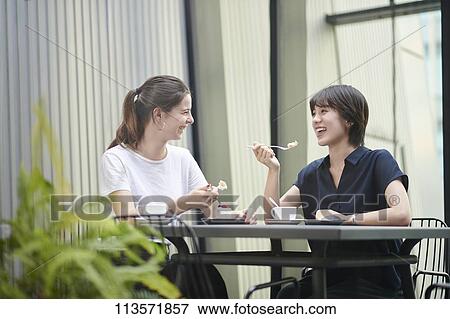 Young girlfriends at a cafe View Large Photo Image Stock Photo - Young girlfriends at a cafe. Fotosearch
