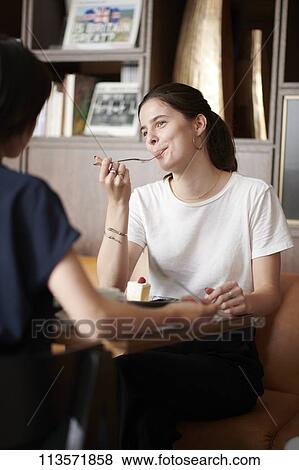 Young girlfriends at a cafe View Large Photo Image Stock Photo - Young girlfriends at a cafe. Fotosearch
