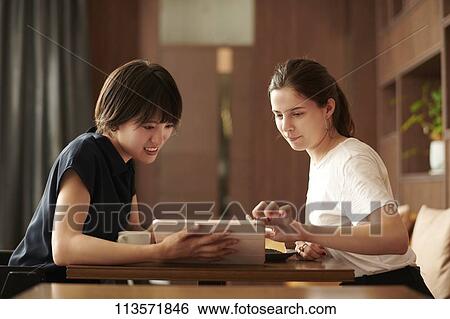 Young girlfriends at a cafe View Large Photo Image Stock Photograph - Young girlfriends at a cafe. Fotosearch