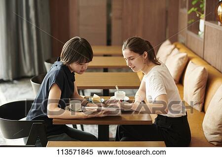 Young girlfriends at a cafe View Large Photo Image Stock Photography - Young girlfriends at a cafe. Fotosearch