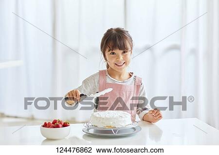 Young happy girl preparing a cake in the kitchen View Large Photo Image Stock Image - Young happy girl preparing a cake in the kitchen. Fotosearch
