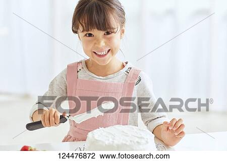 Young happy girl preparing a cake in the kitchen View Large Photo Image Stock Image - Young happy girl preparing a cake in the kitchen. Fotosearch