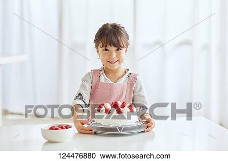 Young happy girl preparing a cake in the kitchen View Large Photo Image Stock Image - Young happy girl preparing a cake in the kitchen. Fotosearch