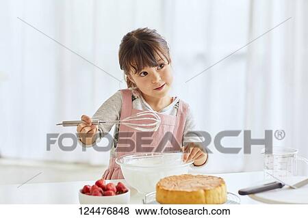 Young happy girl preparing a cake in the kitchen View Large Photo Image Stock Photo - Young happy girl preparing a cake in the kitchen. Fotosearch
