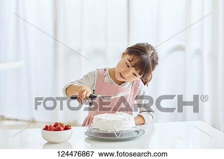 Young happy girl preparing a cake in the kitchen View Large Photo Image Stock Photo - Young happy girl preparing a cake in the kitchen. Fotosearch