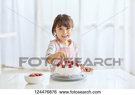 Young happy girl preparing a cake in the kitchen View Large Photo Image Stock Photograph - Young happy girl preparing a cake in the kitchen. Fotosearch
