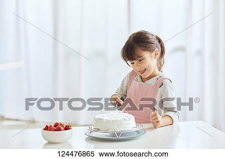 Young happy girl preparing a cake in the kitchen View Large Photo Image Stock Photography - Young happy girl preparing a cake in the kitchen. Fotosearch