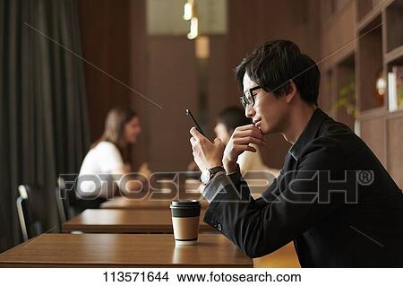 Young Japanese businessman at a cafe View Large Photo Image Picture - Young Japanese businessman at a cafe. Fotosearch