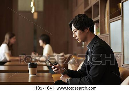 Stock Image - Young Japanese businessman at a cafe. Fotosearch