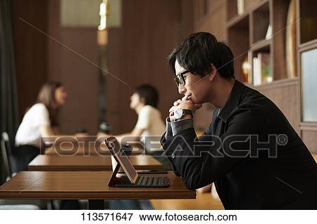 Stock Photo - Young Japanese businessman at a cafe. Fotosearch