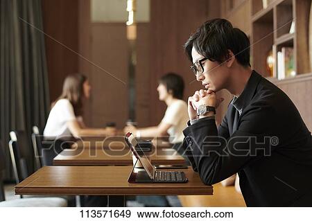 Stock Photo - Young Japanese businessman at a cafe. Fotosearch
