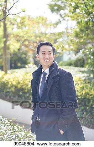 Picture - Young Japanese businessman outside. Fotosearch