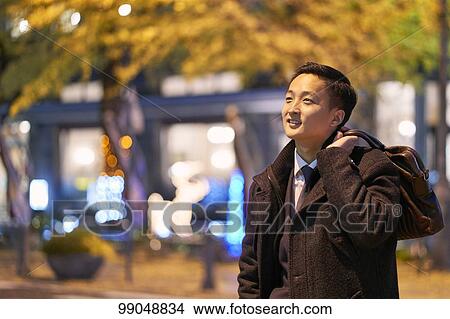 Picture - Young Japanese businessman outside. Fotosearch