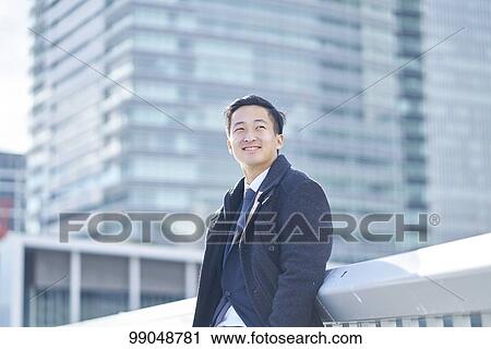 Stock Image - Young Japanese businessman outside. Fotosearch