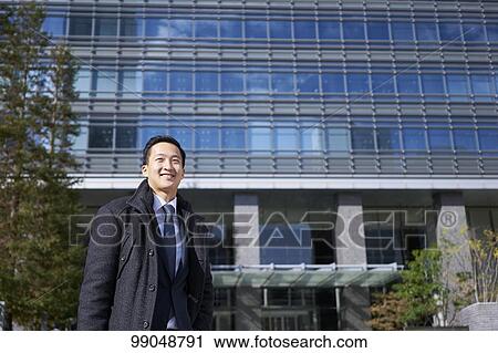 Stock Image - Young Japanese businessman outside. Fotosearch
