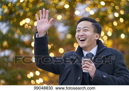 Stock Image - Young Japanese businessman outside. Fotosearch