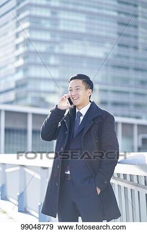 Stock Photo - Young Japanese businessman outside. Fotosearch