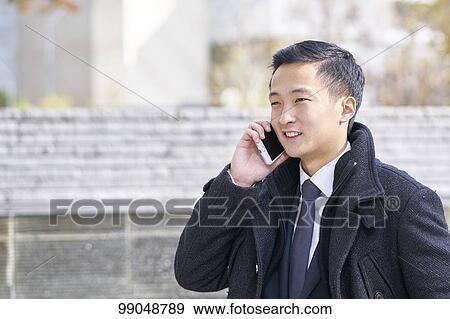 Stock Photo - Young Japanese businessman outside. Fotosearch