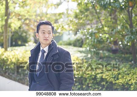 Stock Photo - Young Japanese businessman outside. Fotosearch