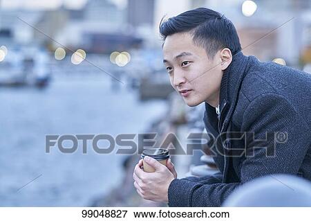 Stock Photo - Young Japanese businessman outside. Fotosearch