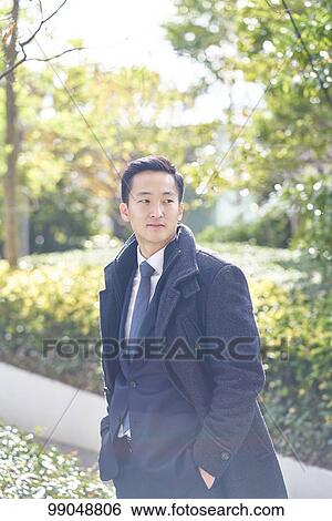 Stock Photograph - Young Japanese businessman outside. Fotosearch