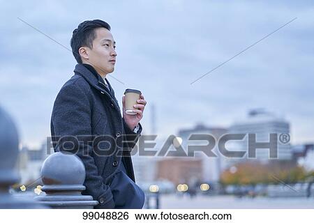 Stock Photograph - Young Japanese businessman outside. Fotosearch