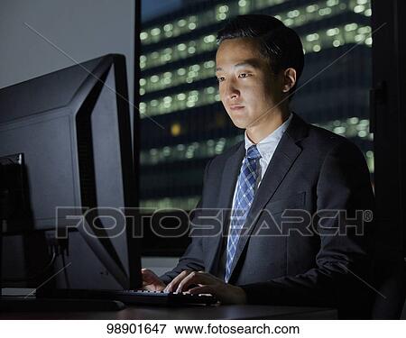 Young Japanese businessman working late at night View Large Photo Image Stock Photo - Young Japanese businessman working late at night. Fotosearch