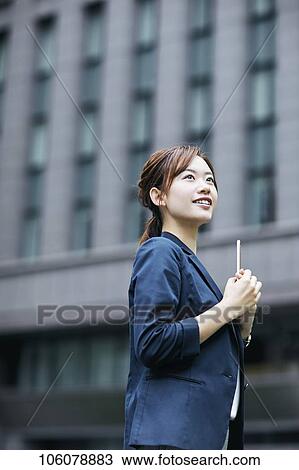 Stock Image - Young Japanese businesswoman downtown. Fotosearch