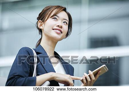 Stock Image - Young Japanese businesswoman downtown. Fotosearch