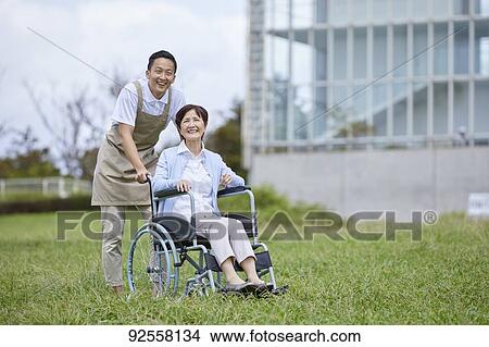 Young Japanese caregiver taking care of elder patient View Large Photo Image Picture - Young Japanese caregiver taking care of elder patient. Fotosearch