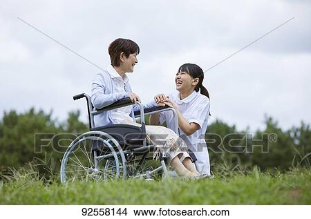 Young Japanese caregiver taking care of elder patient View Large Photo Image Picture - Young Japanese caregiver taking care of elder patient. Fotosearch