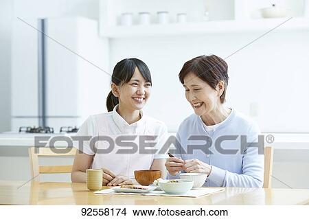 Young Japanese caregiver taking care of elder patient View Large Photo Image Picture - Young Japanese caregiver taking care of elder patient. Fotosearch