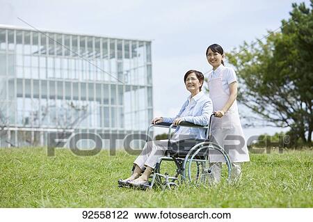 Young Japanese caregiver taking care of elder patient View Large Photo Image Stock Image - Young Japanese caregiver taking care of elder patient. Fotosearch