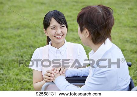 Young Japanese caregiver taking care of elder patient View Large Photo Image Stock Image - Young Japanese caregiver taking care of elder patient. Fotosearch